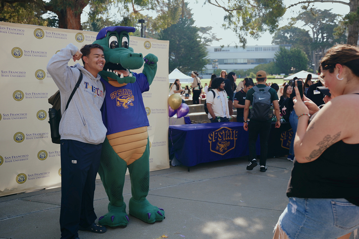 Mascot Alli Gator and student flexing their muscles for a photoshoot